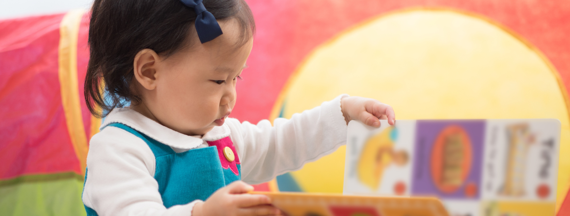 a young toddler plays with books