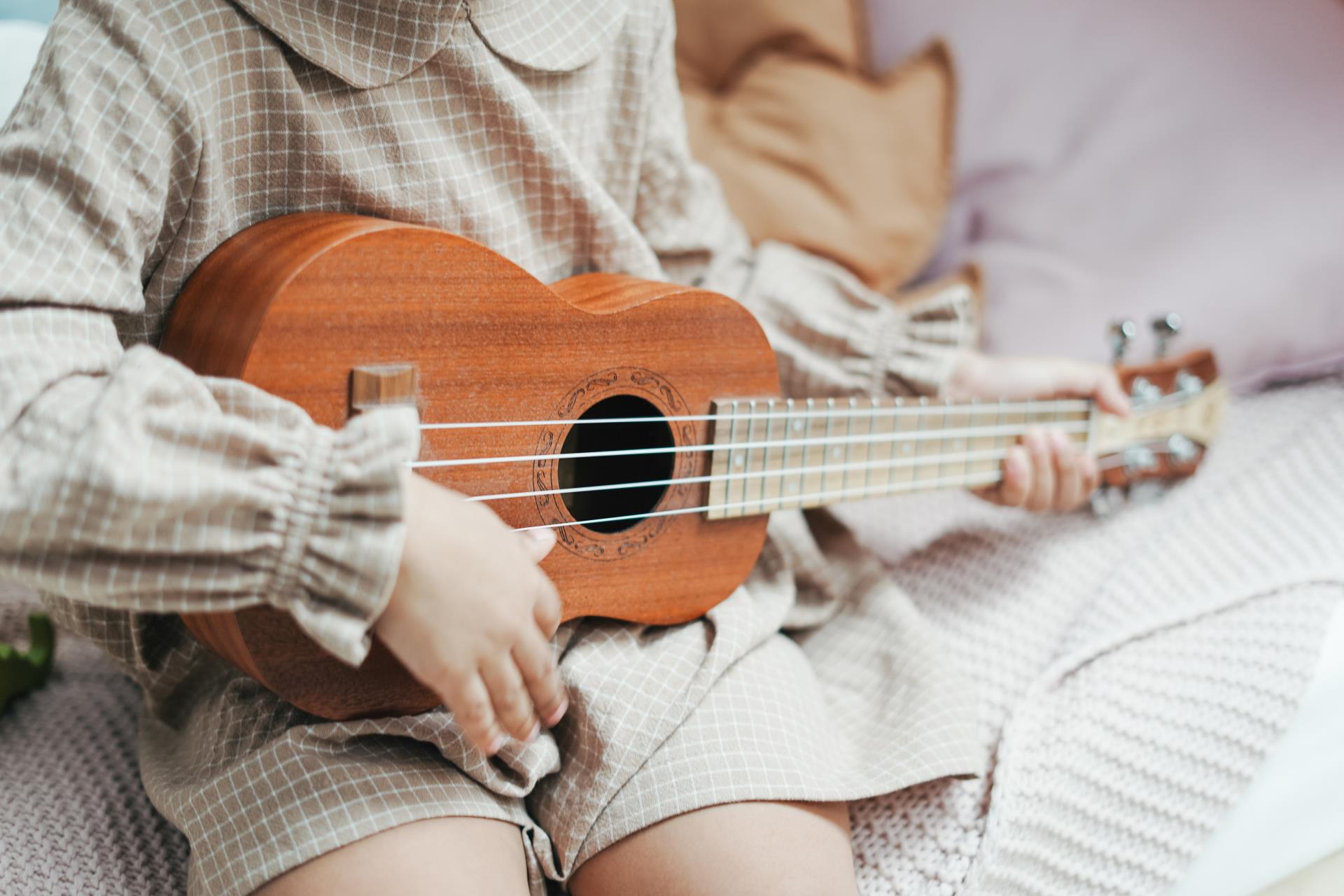 Toddler plays ukulele