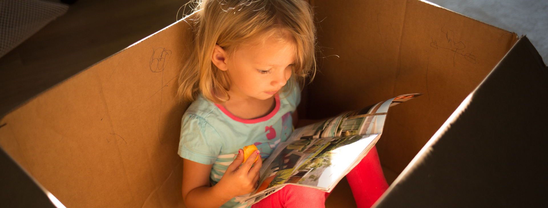 Child reading in box hero