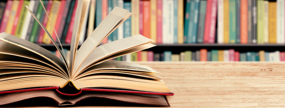 open book in front of shelves of books